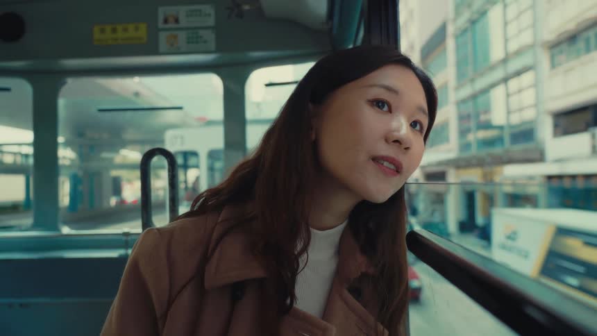 Asian girl looking out of a public transport window and smiling
