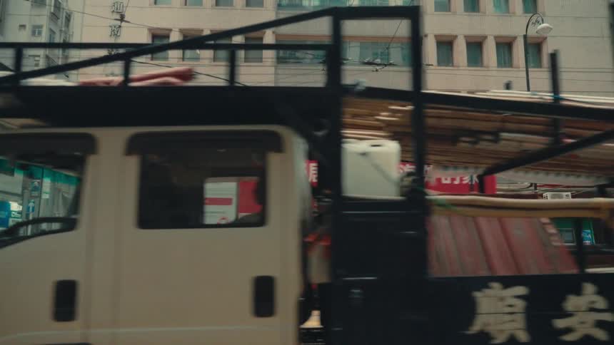 Several vehicles drive down a street