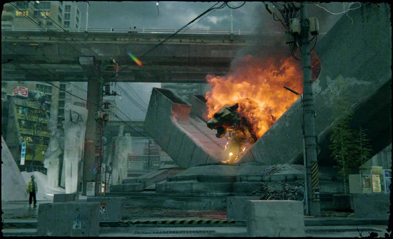 In a cgi urban japanese cityscape a dramatic large fiery blaze envelopes what looks to be a tiger brass statue attracting the gaze of nearby pedestrians placed amongst concrete enviroment which is all under an overpass