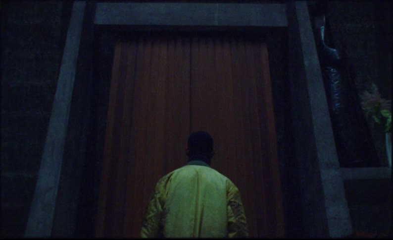 Man walking towards a large door inside a church
