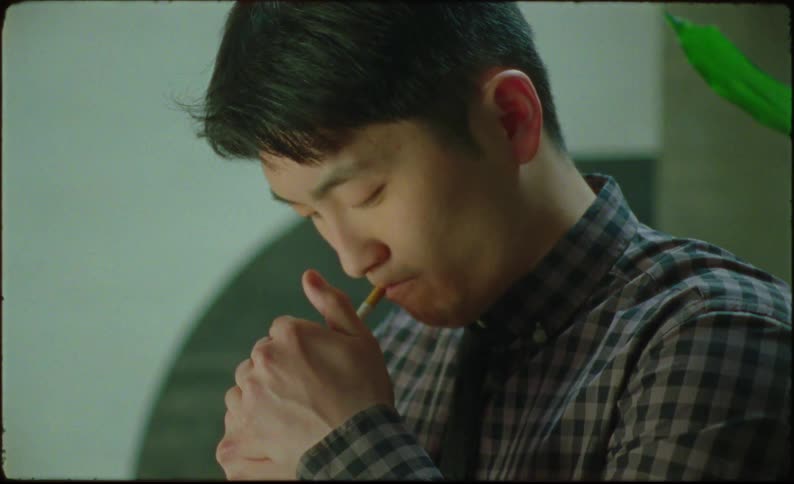 Asian man lighting a cigarette and looking up