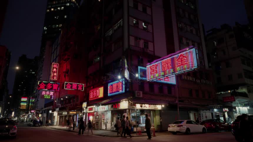 Pedestrians walking on the illuminated streets of Hong Kong at night