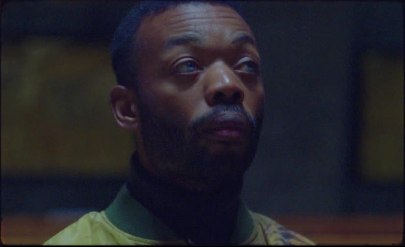 Footage of a black man standing up inside a church