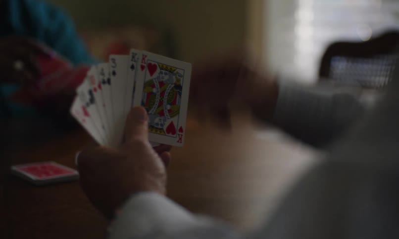 Holding a deck of cards playing gin rummy with a friend