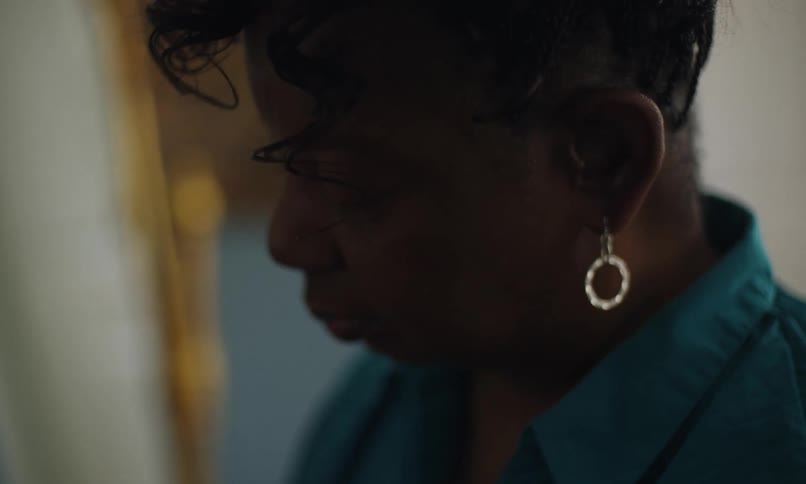 Black woman wearing earrings and is happy