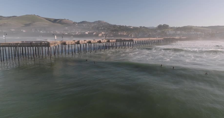 People are surfing near the pier