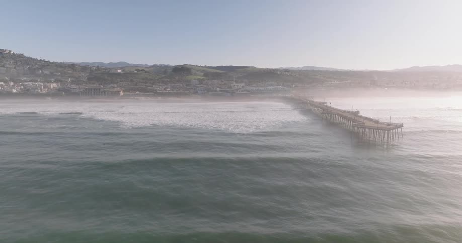 Landscape on a coast with a jetty and lots of fog