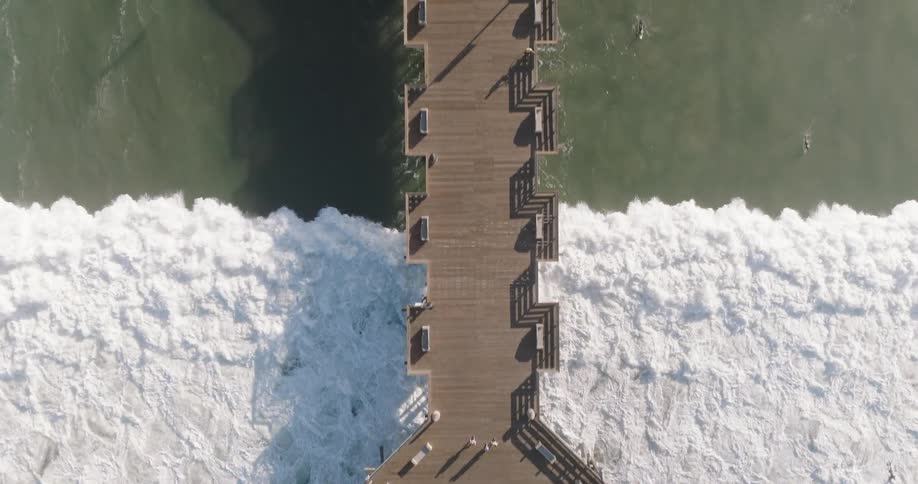 A large wave moves under the pier
