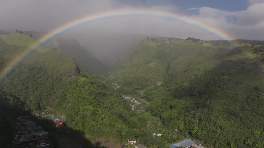 A rainbow arches over a canyon