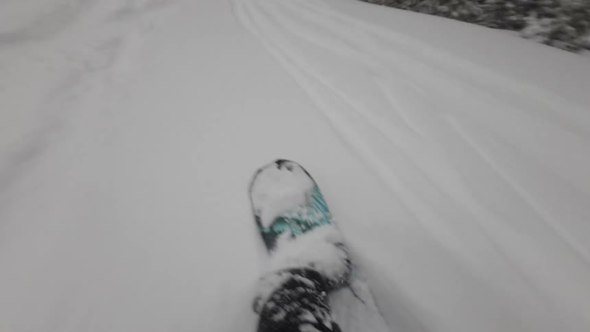 A person is riding a snowboard down a mountain