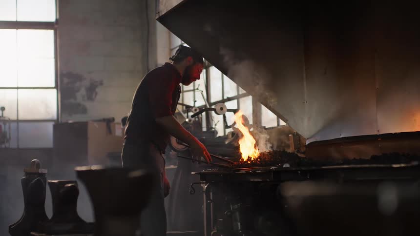 Man working iron with a fire and tools