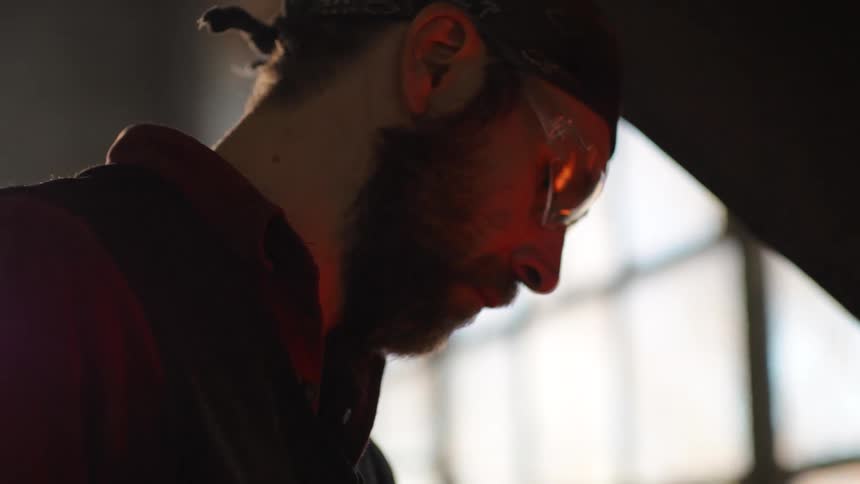 Light reflects in a mans glasses as he looks down