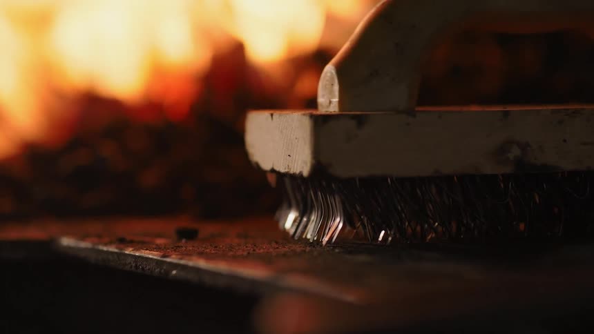 A brush sits near a fire