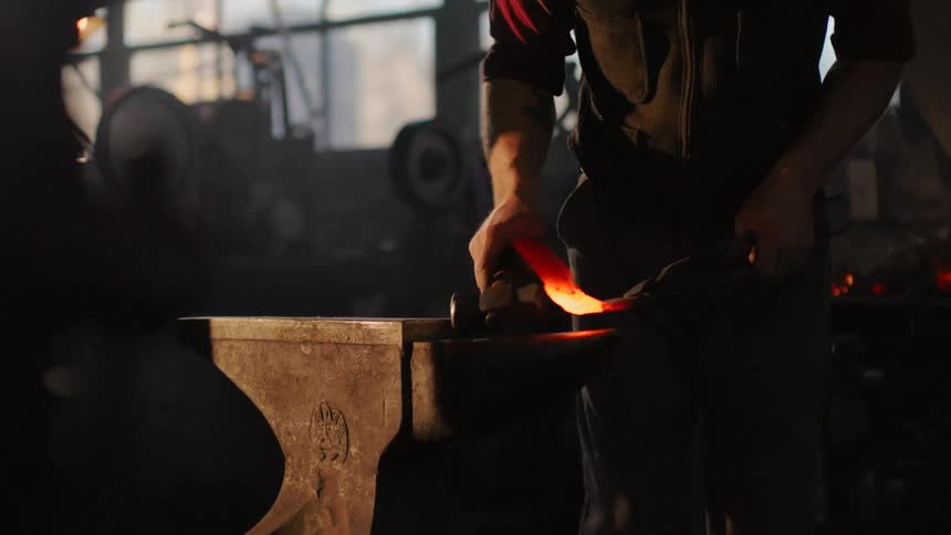 Man beating iron he is forging it