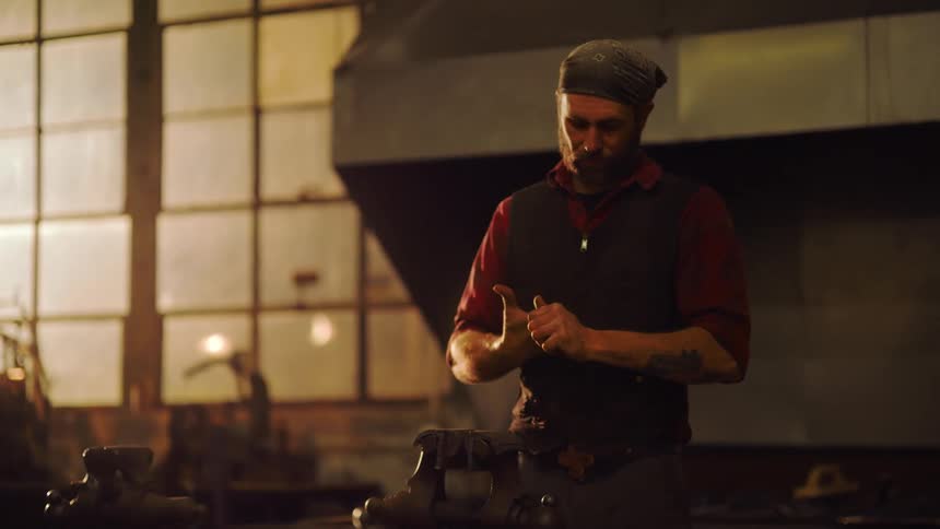 A blacksmith is rubbing his hands together