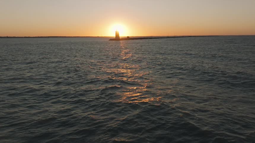 Aerial view of a bay and a lighthouse in the sunset light