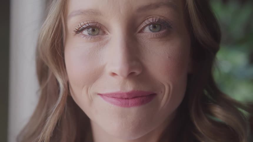 A woman is smiling outside