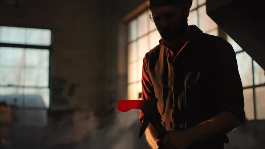 A man brushing a piece of hot steel in a shop