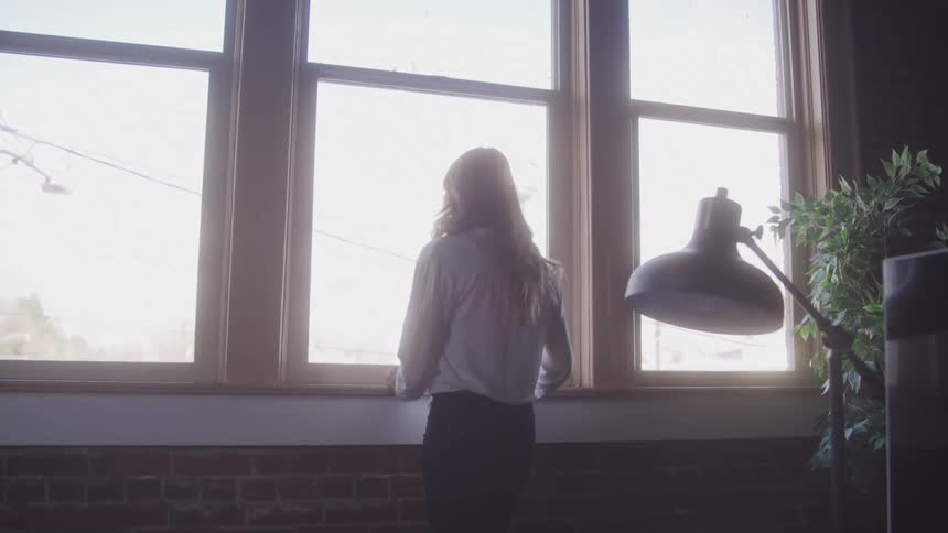 Girl with her back turned looking out the window