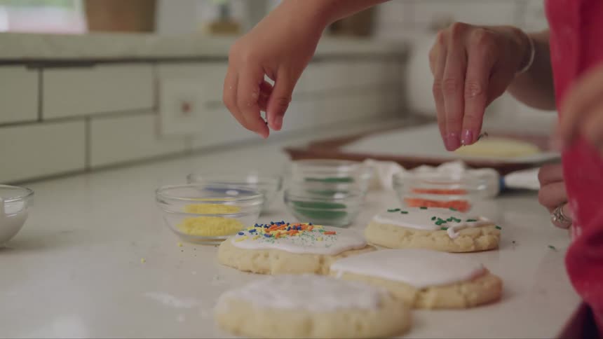 Hands putting pralines on top of sweets