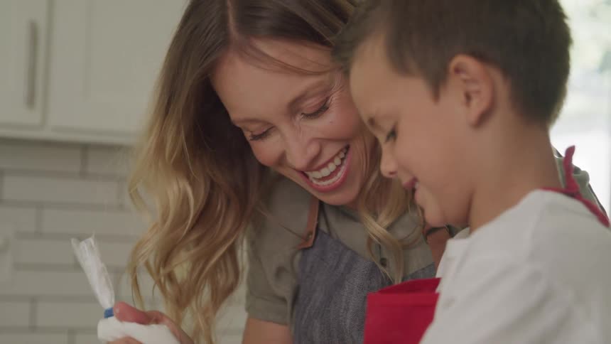 Fun mom and son smiling and laughing as they cook together