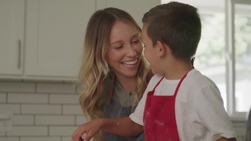 Mom and son cooking together happily laughing