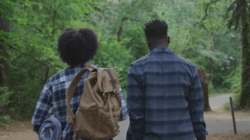 Back view of a woman and a man walking along a nature trail