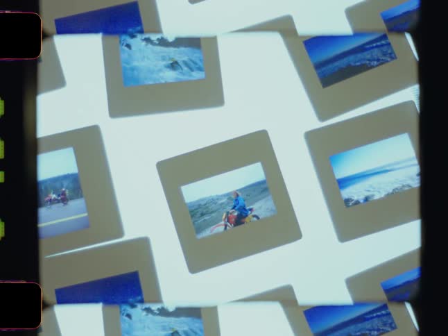 A collection of slide photographs featuring various outdoor scenes is arranged on a brightly lit surface