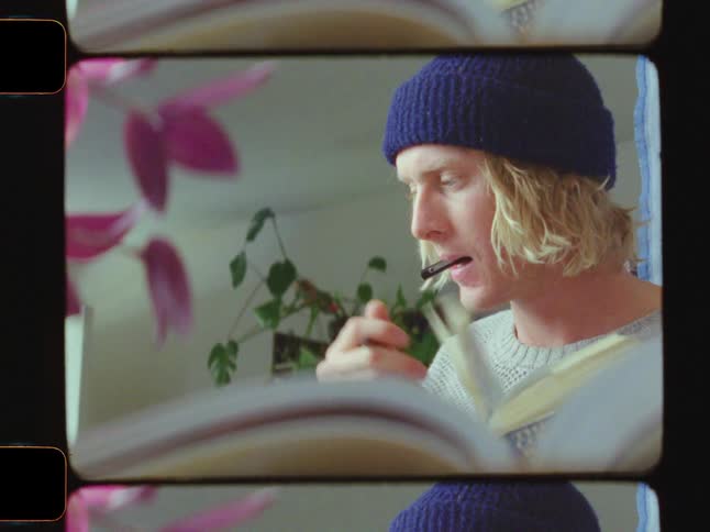 Man flipping through a book looks something over before making a note