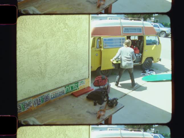 Boy loading many objects on top of a van