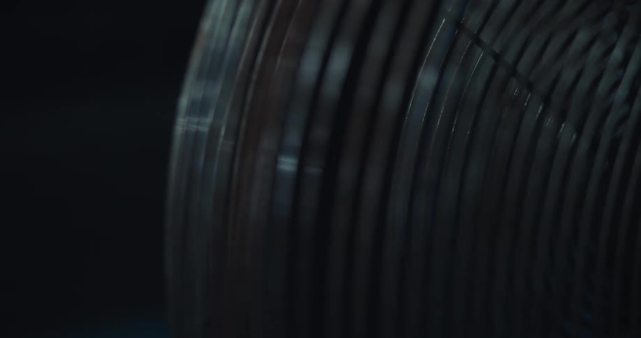 A fan turns on then off in a dark room