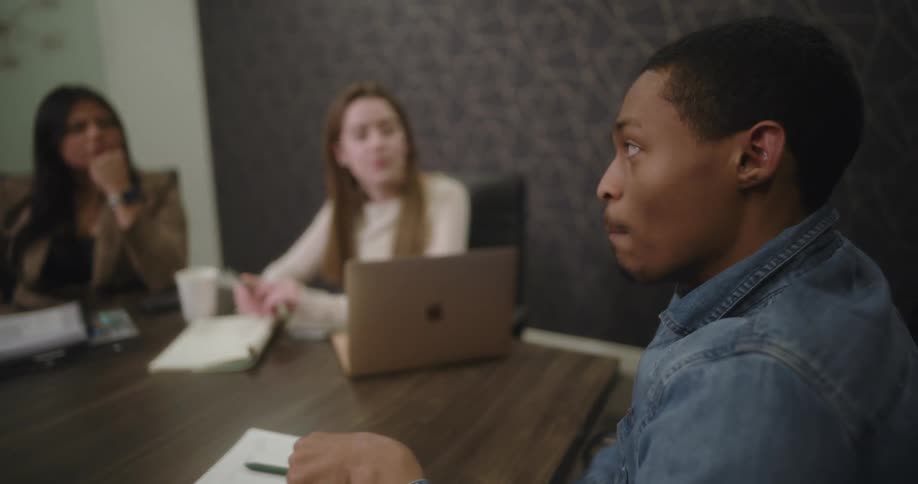 A group of office employees are having a meeting in a conference room