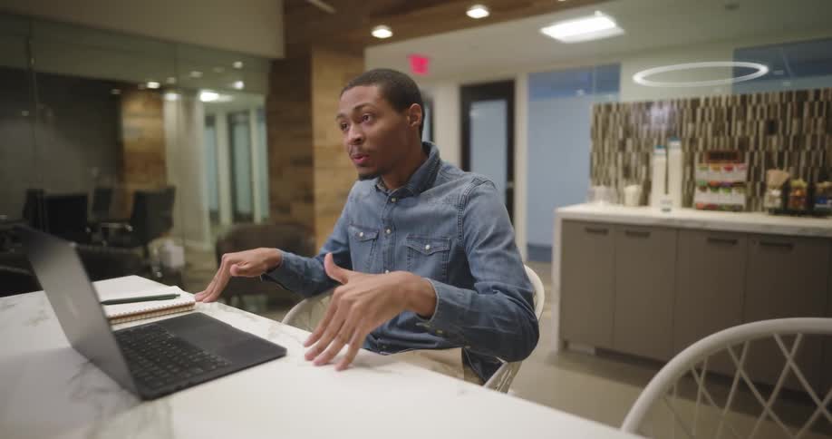A man taps the table while he talks in the office