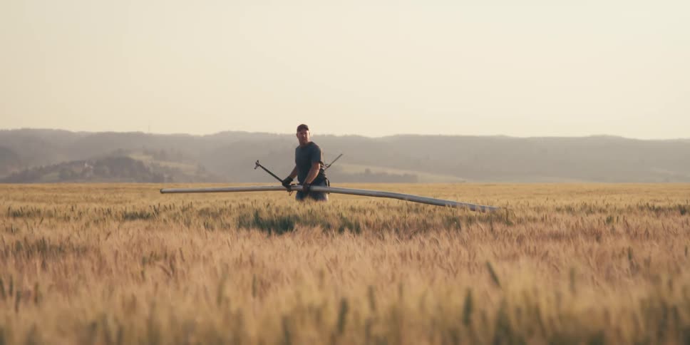 Boy working in a field with a large metal tool