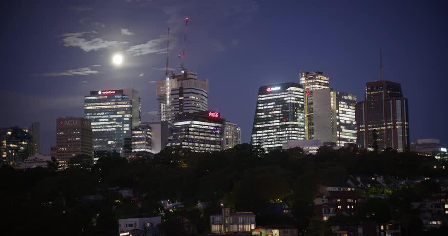A full moon hangs over a city