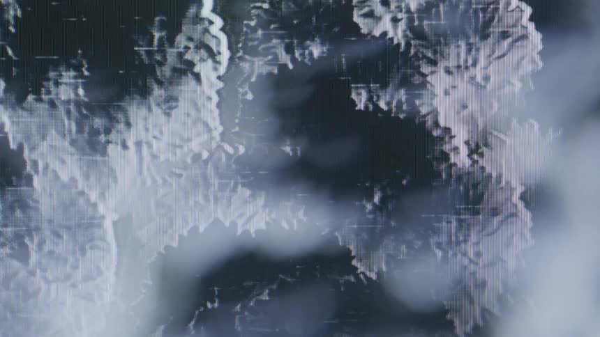 A closeup displays the intricate moving texture of an old analog film characterized by grain and fluctuating light