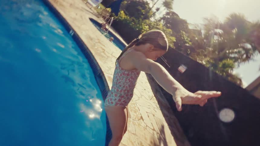 A girl falls backward splashing in the water