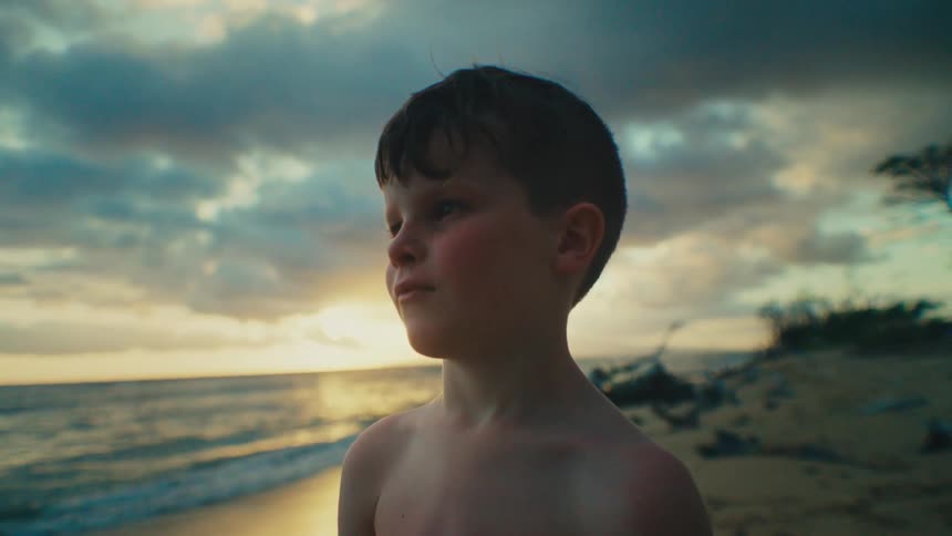 Child on a beach looking at the horizon