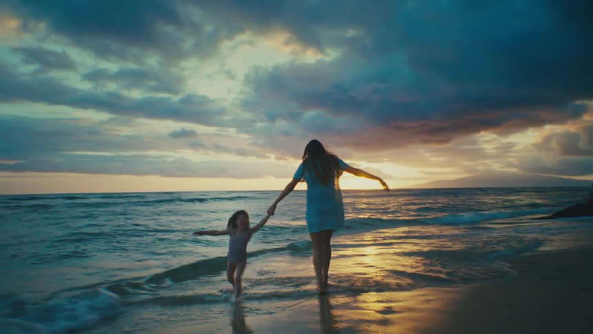 Mom and daughter playing at the seashore