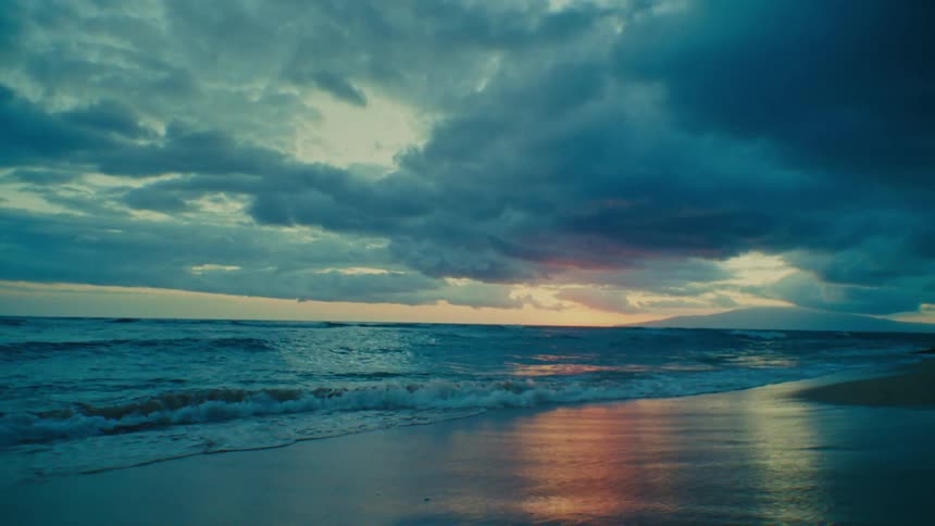 The sun is reflecting off the waves on a beach