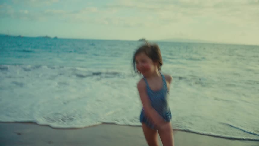 Children run around playing on a beach