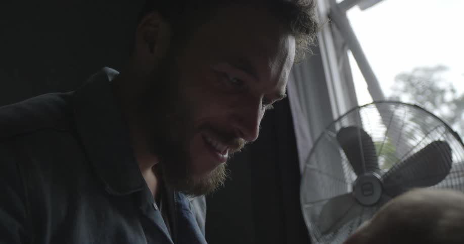 A man smiles down at a baby