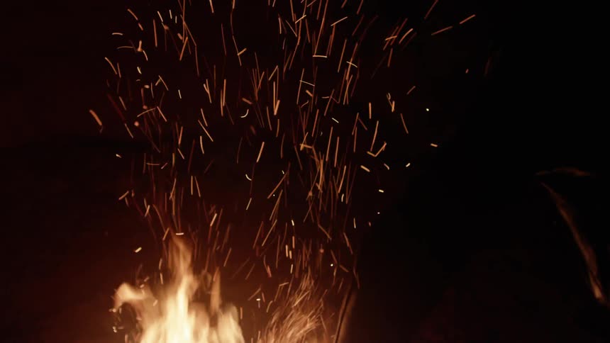 Embers flare up from a burning fire
