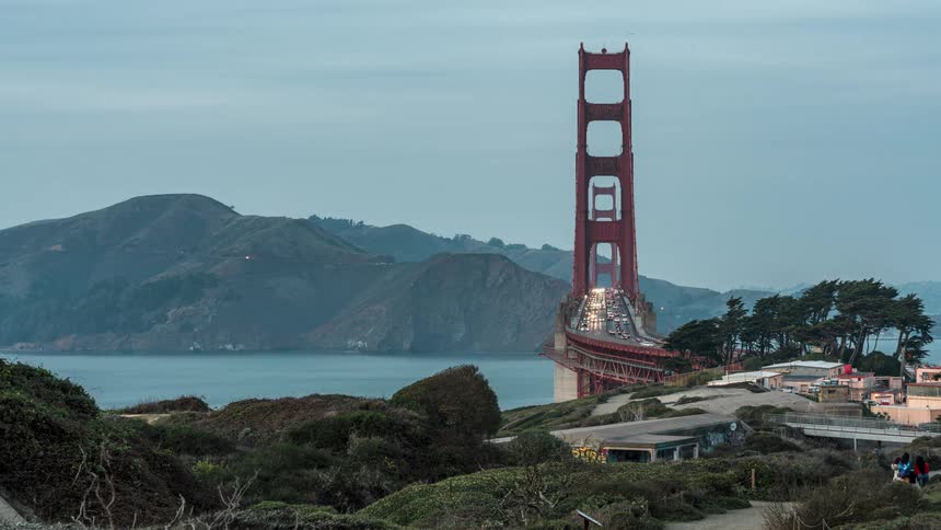 The golden gate bridge illuminated at night with car light trails streaking across its span