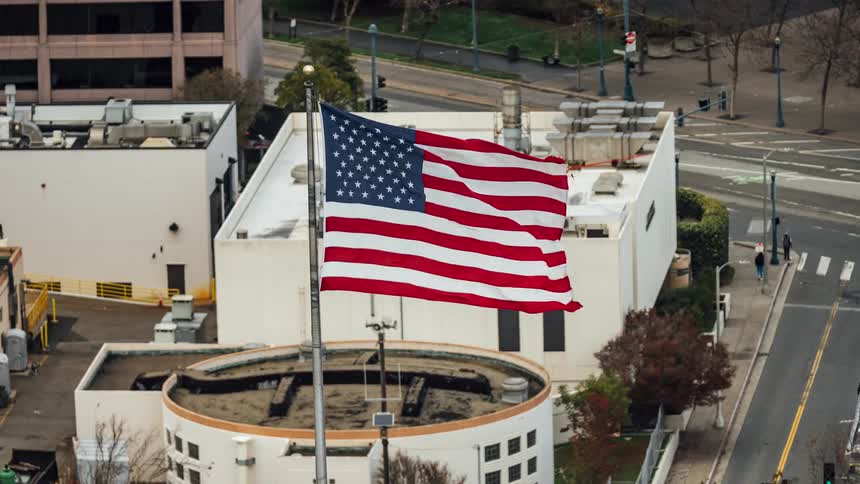 Time lapse american flag blowing in the wind from building