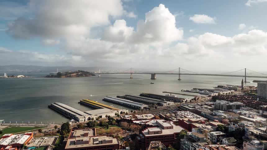 Activity in a harbor near a city bridge