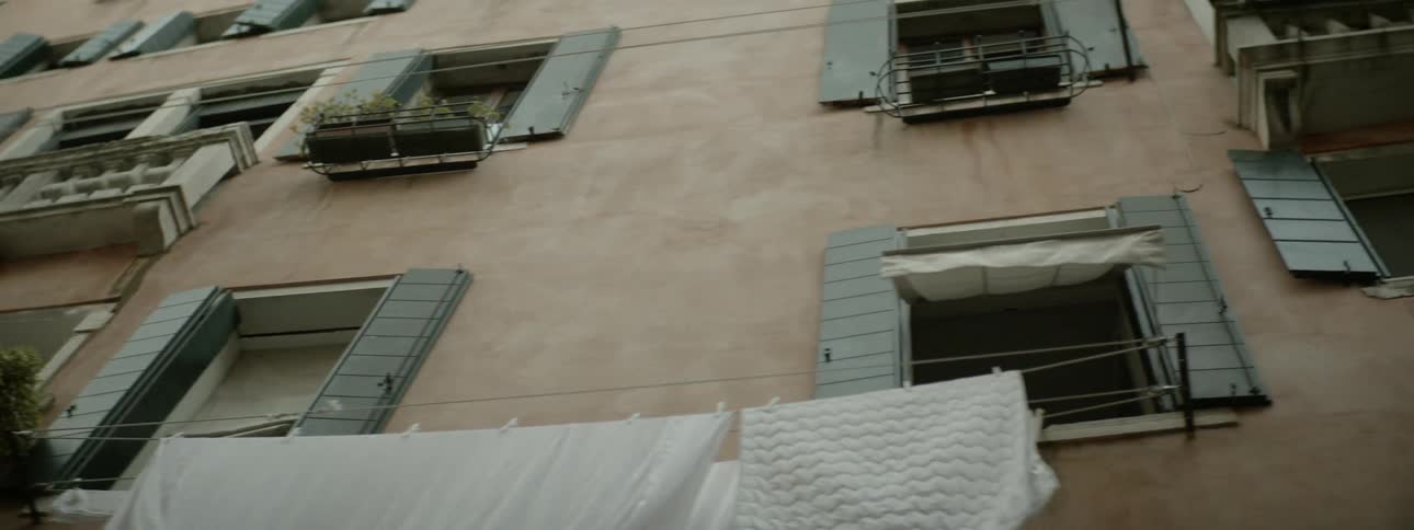 A building with window shutters and plant boxes