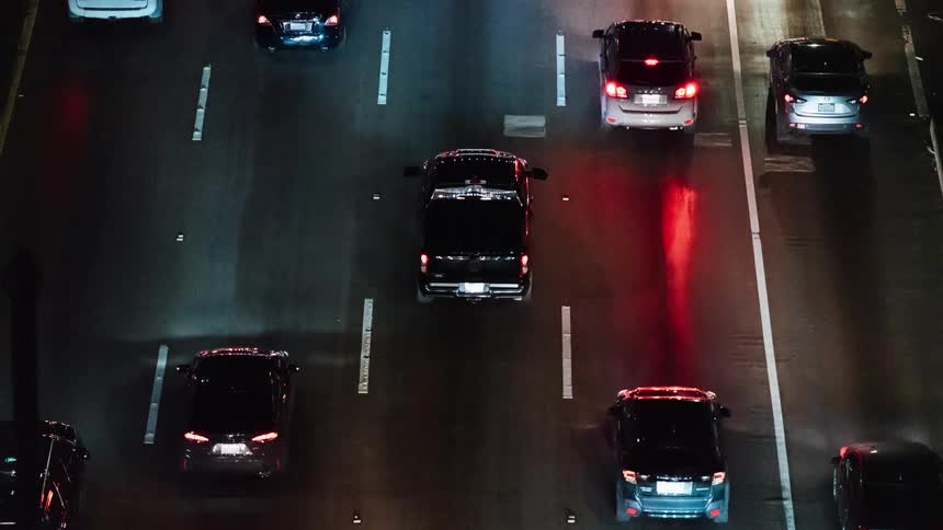 Trucks and cars move in the heavy traffic at night