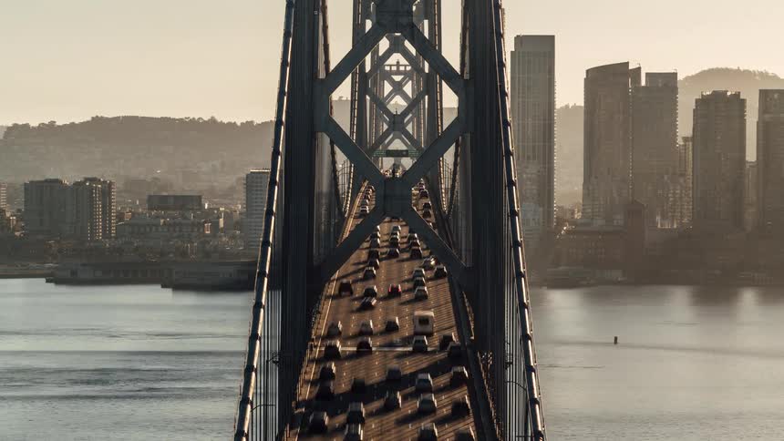 Time lapse of vehicles driving over a bridge near a city