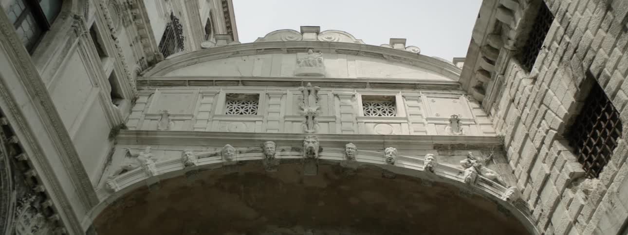 A large stone building is underneath a cloudy sky